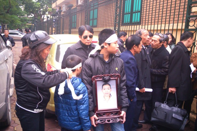 Bà Nguyệt (dì của Khánh) quàng lại khăn tang giúp hai con của nạn nhân.