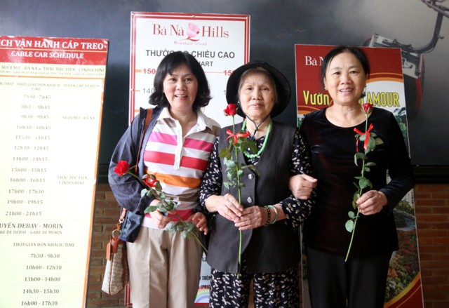 C&ocirc; Hải (b&ecirc;n tr&aacute;i) c&ugrave;ng gia đ&igrave;nh đến từ H&agrave; Nội rất th&iacute;ch th&uacute; khi đi du lịch tại B&agrave; N&agrave; Hills được tặng hoa trong ng&agrave;y 20-10. Ảnh Đ.H