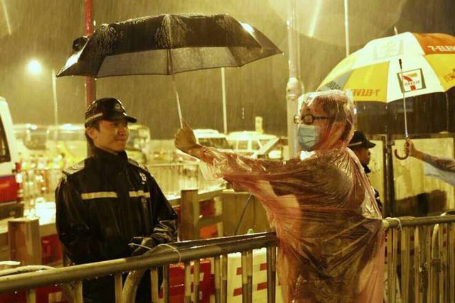 Trong cơn mưa, cảnh sát và người biểu tình dường như không còn ranh giới. Ảnh: News Hong Kong.