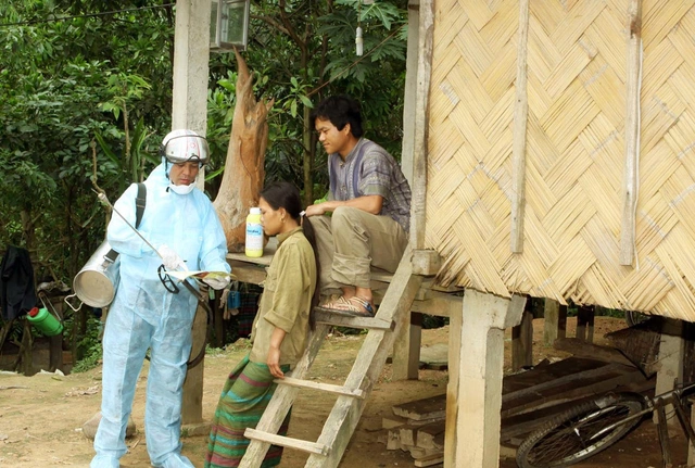 Cán bộ y tế huyện Văn Chấn (Yên Bái) phun thuốc khử trùng, hướng dẫn người dân vệ sinh môi trường sống để đề phòng dịch bệnh. 	 ảnh: Dương Ngọc