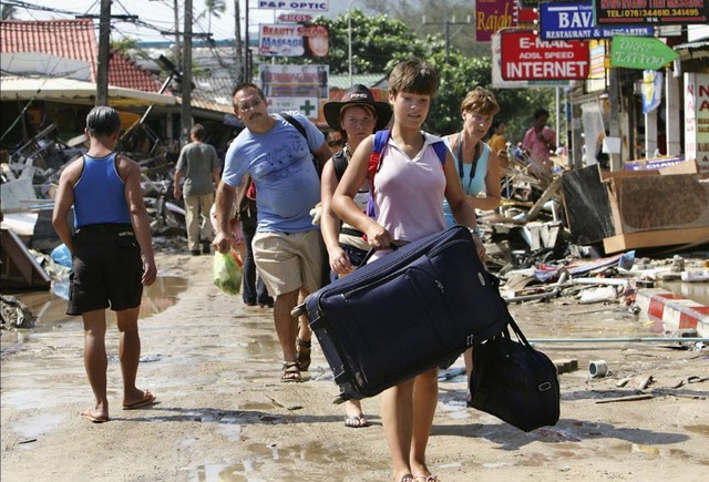 Khách du lịch mang theo hành lý ra sân bay vào 27/12/2004. Bãi biển Patong là một trong những nơi chịu ảnh hưởng nặng nề nhất sau thảm họa này của tỉnh Phuket, Thái Lan.