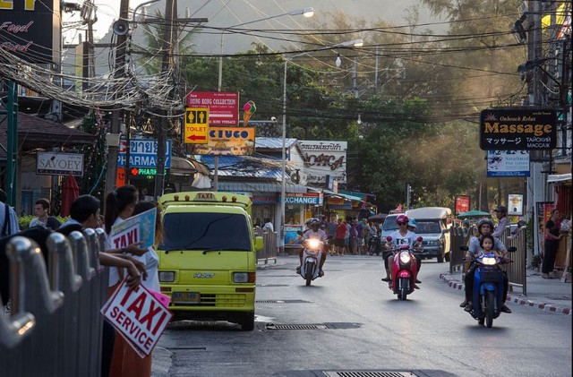 Một góc cảnh của bãi biển Patong 10 năm sau đó, cho thấy xe gắn máy, xe tải, xe ô tô và cả taxi đang đi trên một con phố tấp nập của Patong.