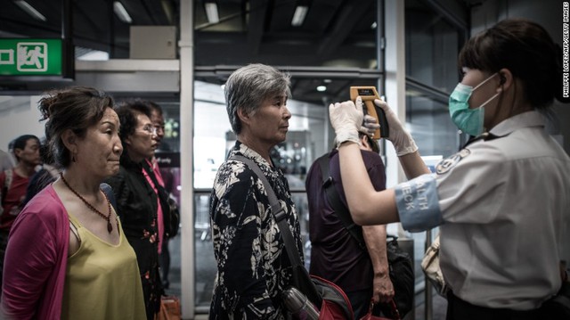 Passengers get their temperatures checked as part of preventive measures against the spread of MERS at the Hong Kong International Airport on June 5.