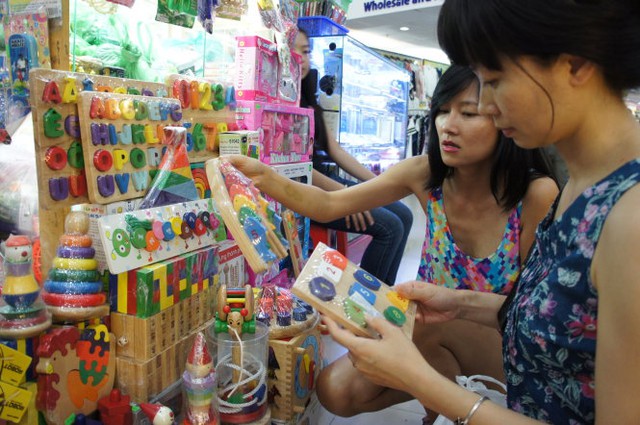 Hai bà mẹ trẻ chọn mua đồ chơi giáo dục bằng gỗ của VN tại một trung tâm thương mại ở Q.1, TP.HCM     Ảnh: T.T.D.