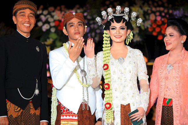 Indonesias President Widodo and his wife smile, as their son Gibran Rakabumi and Rakabumis bride Selvi Ananda show their wedding rings after their wedding ceremony in Solo