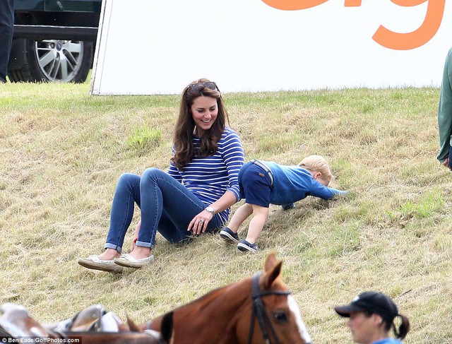 Taking a tumble: The adorable young prince finds himself in a precarious position as his laughing mother looks watches 