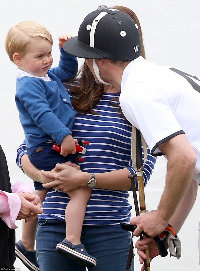 Well played! Prince George tentatively touches his father Prince Williams helmet before pulling his hand away