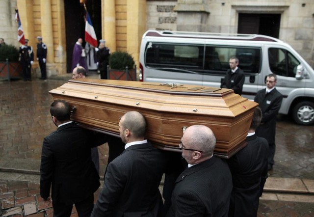 Relatives of Franck Brinsolaro, the police officer charged with protecting late Charlie Hebdo editor Stephane Charbonnier, carry the cops coffin into Sainte Croix Church on Thursday.