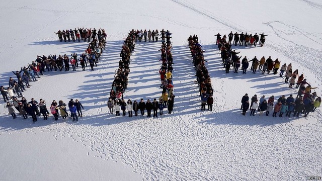 Students form 2015 standing on snow to welcome the upcoming New Year at Shenyang Agriculture University in Shenyang, Liaoning province, 31 December 2014. 