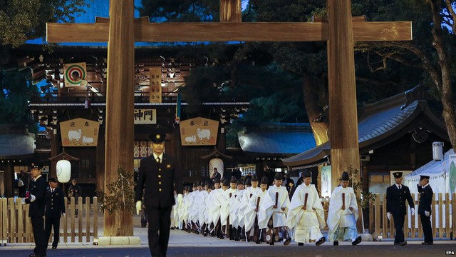 Shinto priests walk through a wooden tore gate after concluding an yearend ritual in preparation for the New Year at the Meiji Shrine in Tokyo, Japan, 31 December 2014. 