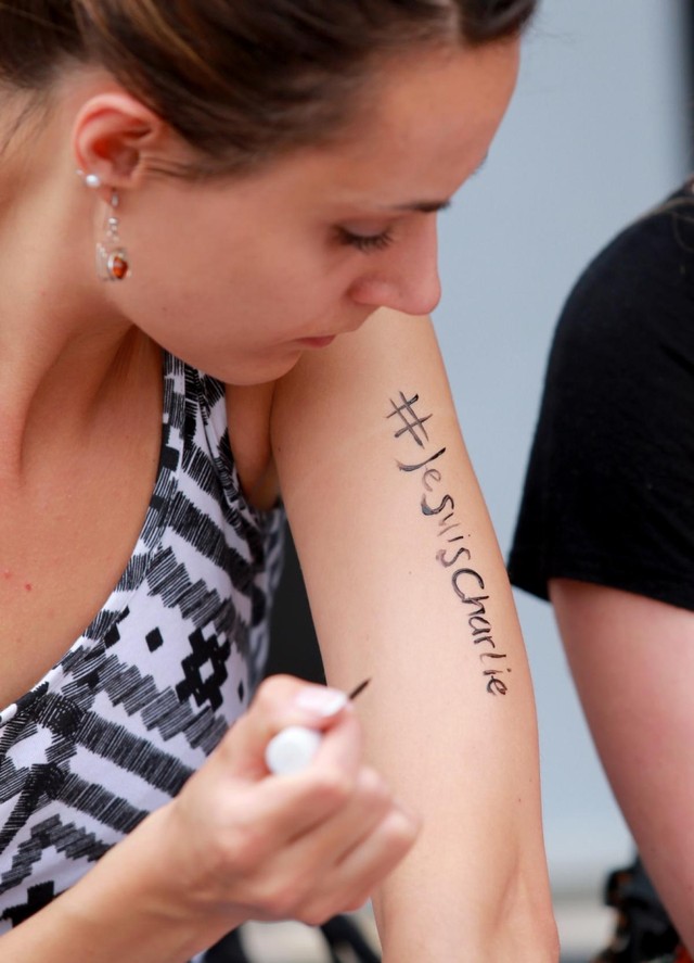 Woman inscribes Je Suis Charlie on her arm during a vigil at Federation Square on January 8, 2015 in Melbourne, Australia, for victims of the deadly Charlie Hebdo massacre.