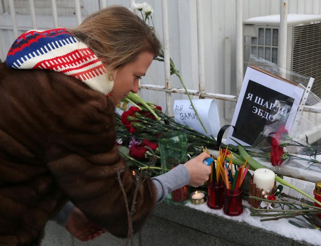 A Russian woman lights candles in front of the French embassy in Moscow, Russia, in solidarity with those killed or injured in yesterdays terror attack at the satirical magazine Charlie Hebdo.