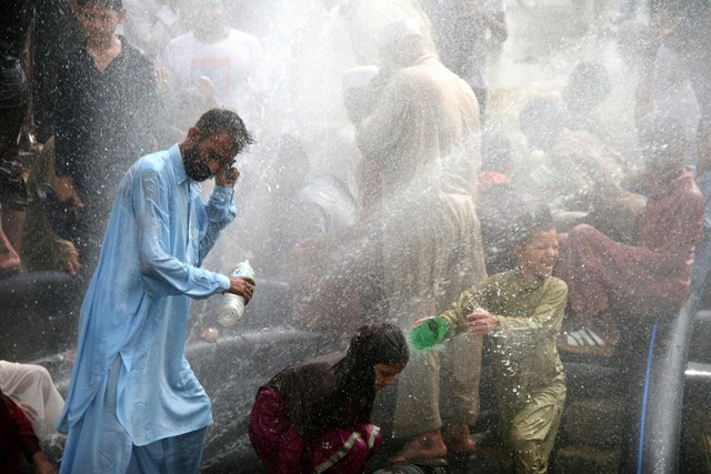 Những người dân thường tại Pakistan đang lấy nước để té lên mình cho bớt nóng giữa cơn nắng nóng dữ dội, nhờ một đường ống cấp nước ở Karachi