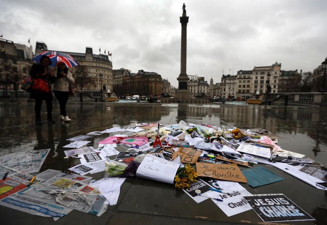 Flowers, pens and placards have been left at a memorial in Trafalgar Square, London, early Thursday morning to show solidarity with those killed in an attack at the Paris offices of weekly newspaper Charlie Hebdo.