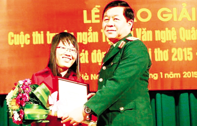 Trung tướng Nguyễn Trọng Nghĩa, Phó chủ nhiệm Tổng cục Chính trị trao giải Nhất cho Nguyễn Thị Kim Hòa. 	Ảnh: TL