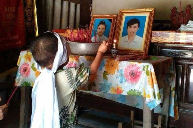 Hình ảnh bé Nguyễn Gia Bảo đầu đeo khăn tang thắp hương lên bàn thờ cha mẹ. 	Ảnh: X.Thắng