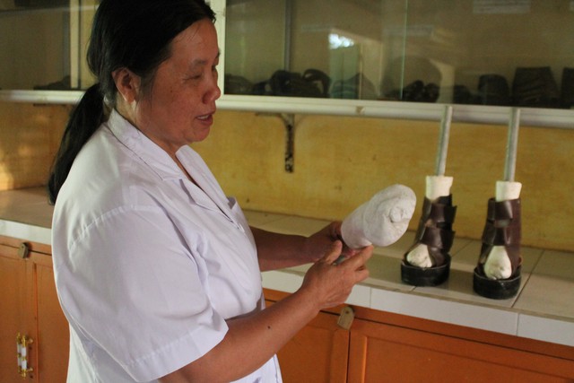 Y tá Nguyễn Thị Xuân bên những đôi dép mà bà tự tay làm cho bệnh nhân.	 Ảnh: P.B