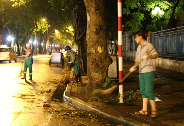 Sau cơn dông, lực lượng công nhân môi trường khá vất vả. Trong ảnh là các công nhân đang dọn dẹp trên tuyến phố Phan Đình Phùng