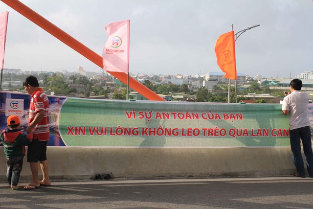 Chủ đầu tư và đơn vị thi công đã treo băng-rôn khuyến cáo người dân không nên trèo qua lan can cầu để tránh những tai nạn đáng tiếc xảy ra.