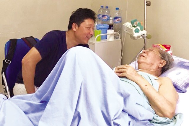 Nhạc sĩ Hoàng Vân đang được con trai - nhạc trưởng Lê Phi Phi - động viên điều trị bệnh (ảnh gia đình cung cấp).
