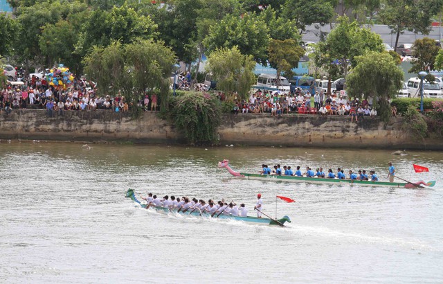 Hàng ngàn du khách và người dân phố biển Đà Nẵng đứng hai bên bờ sông Hàn reo hò, cổ vũ cho các đội đua...