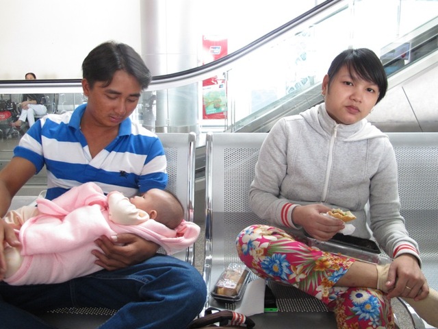 Vợ chồng anh Lê Văn Tuấn và chị Võ Thị Nhi phải bồng con nhỏ gần 10 tiếng đồng hồ ở phòng chờ vì JetstarPacific liên tục trễ giờ bay. Ảnh Đ.H