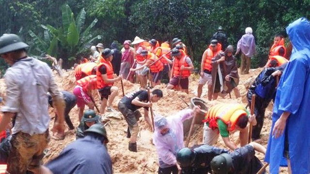 Lực lượng chức năng cùng nhân dân khẩn trương đào bới đất đá tìm kiếm người thân anh Cao Văn Vỹ sau vụ lở đất chôn vùi căn nhà.