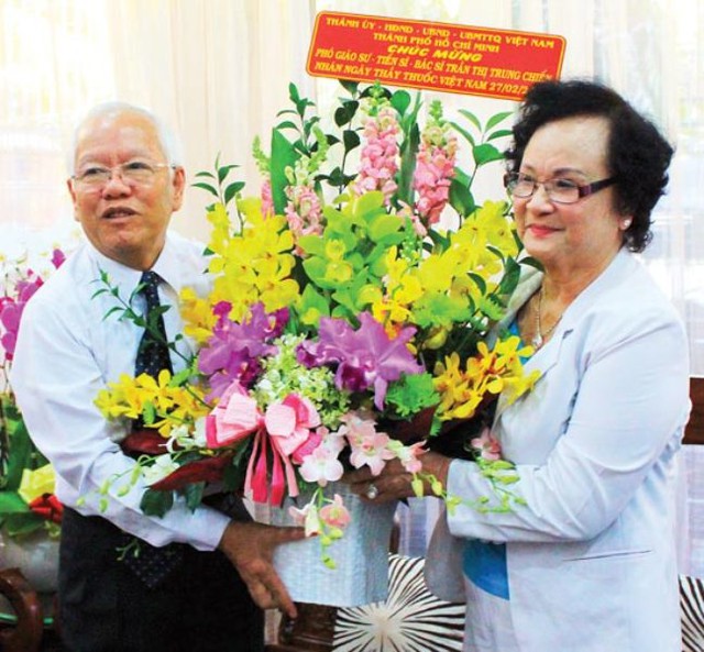 Ông Lê Hoàng Quận-Chủ tịch UBND TPHCM trao tặng lẵng hoa chúc mừng ngày Thầy thuốc VN đến bà Nguyễn Thị Trung Chiếng, nguyên Bộ trưởng Bộ Y tế