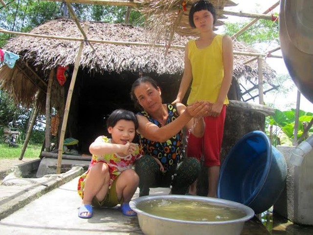 Chị Nguyễn Thị Lý (45 tuổi), ô nhiễm đã làm chị mất đi 3 người thân là chồng và bố mẹ chồng, ngoài ra cũng khiến 2 đứa con gái của chị (bên cạnh) bị bại não, ngây dại.