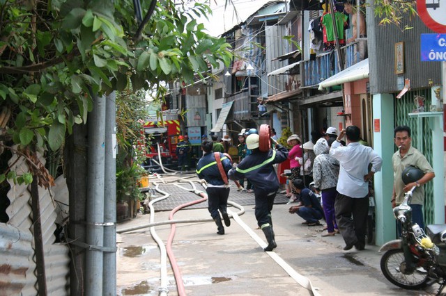 Các chiến sĩ hộc tốc vác ống chữa cháy.