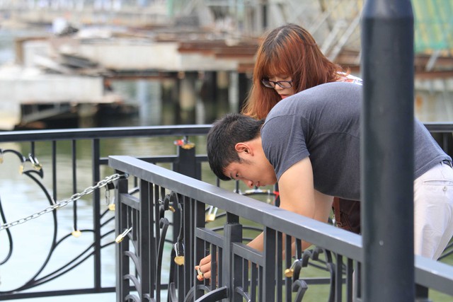 Một cặp đôi cùng nhau khóa tình yêu và cùng nhau ghi dấu kỷ niệm trên cầu tàu tình yêu...