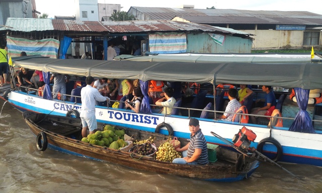 Du khách vừa đến chợ nổi, tùng tốp ghe chở đủ loại hoa quả, hàng hóa nhanh chóng tiếp cận để mời chào.