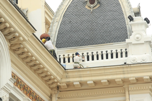 Những tốp thợ đang tỉ mỉ sơn lại các chi tiết kiến trúc bên ngoài của Nhà Hát lớn.