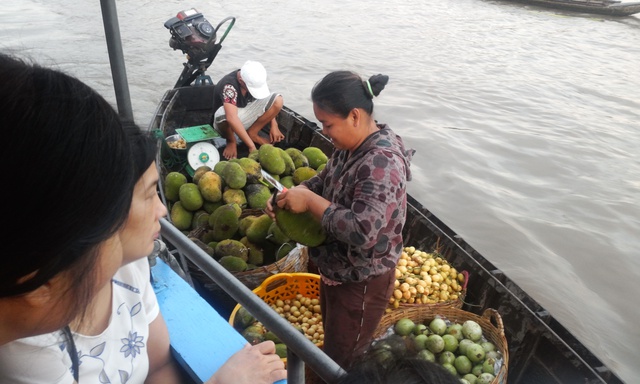 Chủ hàng không ngại bổ hoa quả ngay trên thuyền để khách mua ăn thử.