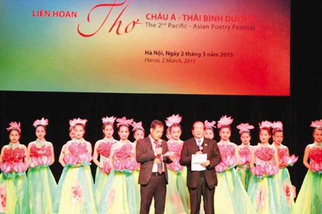Nhà thơ Hữu Thỉnh, Chủ tịch Hội Nhà văn Việt Nam (bên phải) phát biểu khai mạc Liên hoan thơ châu Á - Thái Bình Dương lần thứ II tối 2/3 tại Hà Nội. 	Ảnh: TL