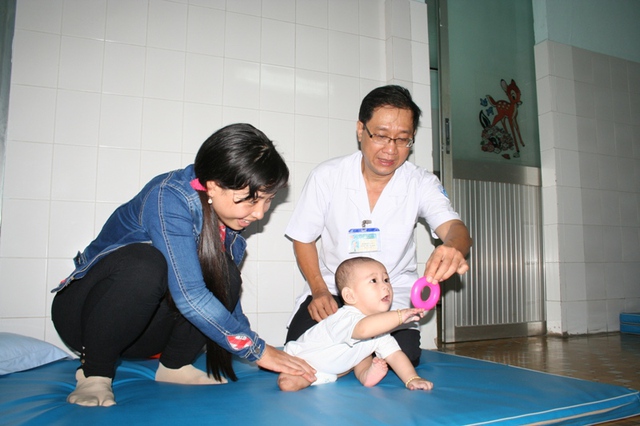 Trưởng khoa vật lý trị liệu BV Nhi đồng 1 đang hướng dẫn dì năm bé văng khỏi bụng mẹ cách giúp bé vận động hàng ngày.