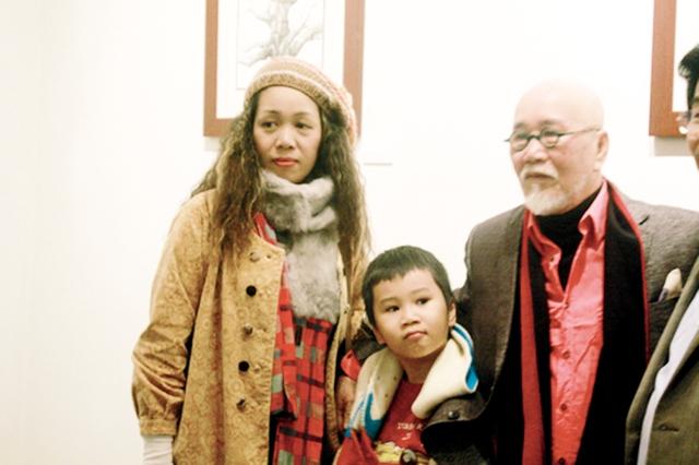 Họa sĩ Trịnh Cung và vợ con tại triển lãm. 	Ảnh: L.Mai