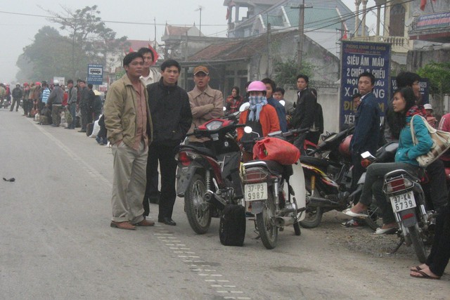 Sau Tết, người dân đứng dọc quốc lộ 1A bắt xe quay lại Hà Nội mưu sinh. 	Ảnh: HP