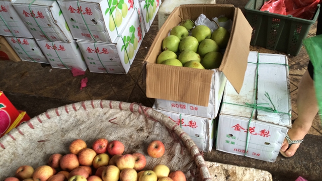 Chủ các sạp hàng thản nhiên lấy táo, lê từ các thùng Trung Quốc ở phía sau và bán cho khách hàng với “danh” hoa quả miền Nam. 	ảnh: TG