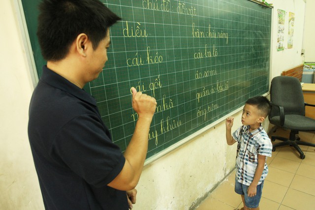 Trẻ điếc học ngôn ngữ ký hiệu từ thầy giáo điếc tại Trường Câm Điếc Xã Đàn, trong Dự án IDEO. 	Ảnh: Chí Cường
