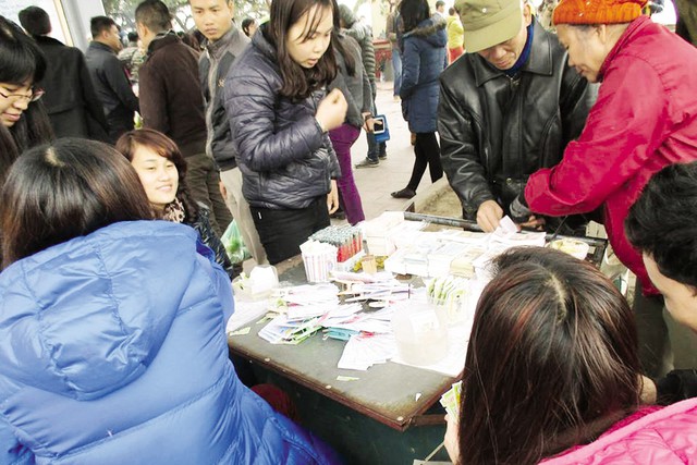Hoạt động đổi tiền lẻ “ăn” chênh lệch vẫn tiếp diễn ở phủ Tây Hồ ngày 3/2. 	ảnh: Nguyễn Mai
