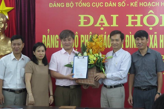 Lãnh đạo Tổng cục DS-KHHGĐ và 	Báo GĐ&XH trao quyết định cho  ông Trần Tuấn Linh. 	Ảnh: PV