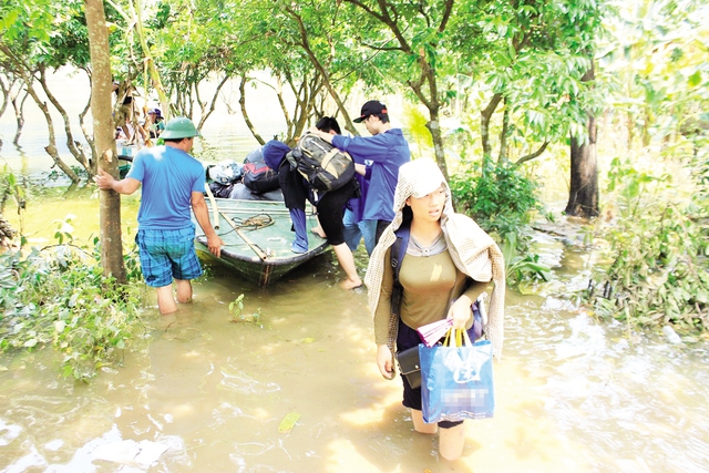 Các đoàn cứu trợ phải lội bì bõm vào trong làng vì ngập lụt vẫn kéo dài. 	
Ảnh: Lý Trung