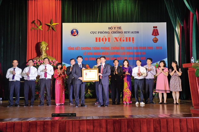 Thừa lệnh Chủ tịch nước, thay mặt lãnh đạo Bộ Y tế, Thứ trưởng Nguyễn Thanh Long trao Huân chương Lao động hạng Ba cho tập thể Cục Phòng, chống HIV/AIDS. 	 Ảnh:  Tuấn Dũng