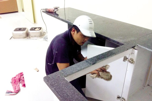 Anh Nguyễn Đình Cường (quê ở Đông Sơn, Thanh Hóa) đang thi công lắp đặt bệ bếp cho một gia đình ở quận Hoàng Mai, Hà Nội.	Ảnh: Q.Anh