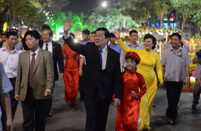 Chủ tịch nước Trương Tấn Sang cùng phu nhân (áo dài vàng) tham qua Đường hoa Tết Ất Mùi với đông đảo người dân TP