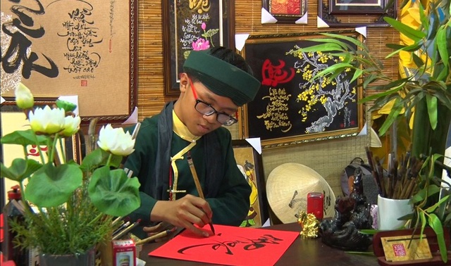 Ông đồ trẻ Võ Tuấn Xuân Thành đang viết chữ cho khách.