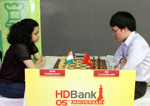 Lê Quang Liêm (phải) thi đấu ván thứ 9 với kỳ thủ Padmini Rout (Ấn Độ)