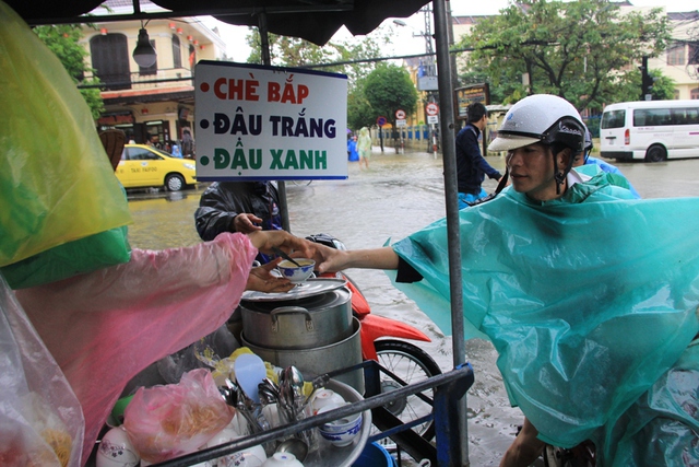 Trong khi nước lũ lên ngập phố cổ, những chiếc xe bán hàng rong vẫn tấp nập khách vào mua. Đây là nét đặc trưng ở phố cổ mà chưa hẳn nơi nào có được