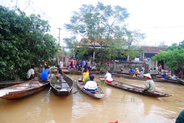 Dù đường đến nhà em vẫn bị ngập phải đi bằng thuyền, nhưng người đến tiễn Kim Anh vẫn rất đông. Ảnh: Hoàng An